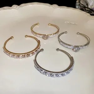 Detailed view of silver and gold double-layer bangles with sparkling water drop zirconia.