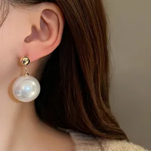 Élégantes boucles d'oreilles pendantes en perles dorées de style français.