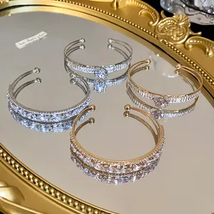 Detailed view of elegant double-layer zircon open bangles on a vintage gold mirror tray