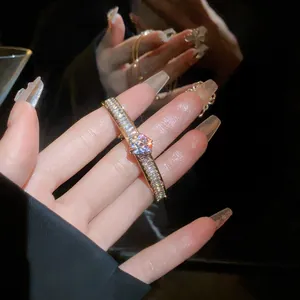 Close-up of a sparkling zircon double-layer open bracelet worn on a female hand