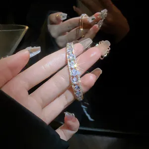 Detailed view of a luxury gold double-layer open bangle featuring sparkling teardrop zircons