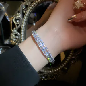 Detailed macro view of an elegant double-layered open bangle featuring sparkling teardrop zircon stones