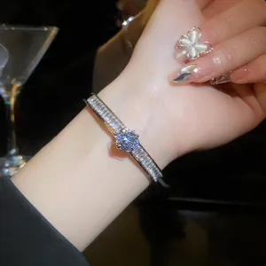 Elegant zircon open bangle shown on a model's wrist in a luxury evening setting