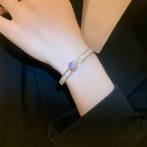 Close-up detail of a luxury gold-plated bangle set with sparkling white zircon stones