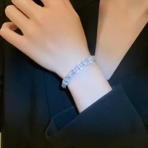Elegant double-layer silver bracelet with teardrop zircons worn on model wrist.