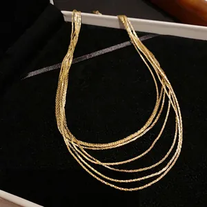 Close-up detail of a layered gold plated necklace inside a black velvet display box.