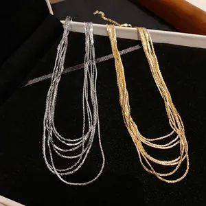 Close-up of elegant gold and silver multi-layered necklaces presented in a jewelry box