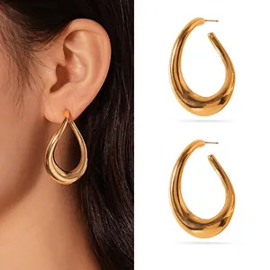 Close-up of large gold teardrop hoop earrings in stainless steel on a model's ear