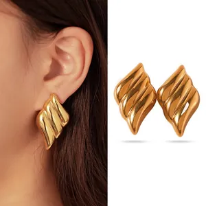 Macro view of gold-tone wavy flame-shaped stainless steel chunky stud earrings