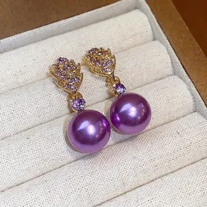 Elegant leaf-shaped gold earrings with purple pearls and rhinestones on silver pins