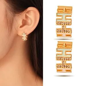 Elegant gold-plated stainless steel C-shaped hoop earrings with H-motif, enamel and zircons.