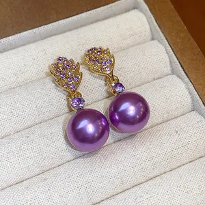 Elegant purple pearl drop earrings with gold leaf studs and purple crystal accents