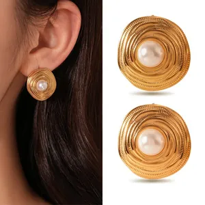 Detail of gold spiral earrings with pearl center shown on model's ear and flat lay