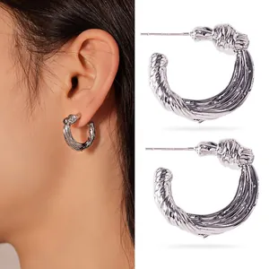 Detailed view of chunky silver stainless steel hoop earrings with a stylish twisted texture