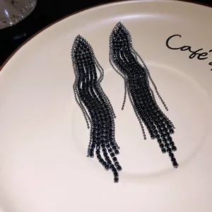 Close-up detail of elegant black rhinestone tassel earrings with a unique triangular design