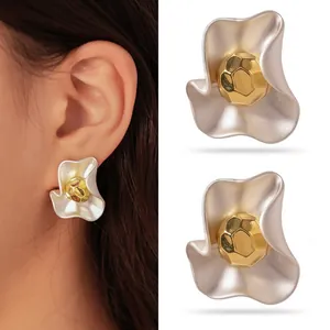 Detailed view of matte silver and gold irregular shaped stainless steel stud earrings