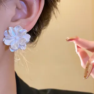 Dettaglio di un elegante orecchino a fiore bianco testurizzato in stile vintage