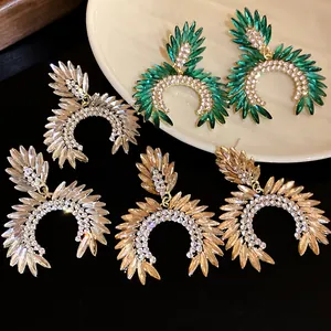 Close-up of luxury rhinestone chandelier earrings with sparkling rice-grain crystals