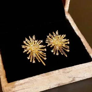 Sparkling gold firework stud earrings with baguette zirconia in jewelry box