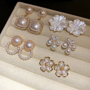 Dettaglio di un set da 10 pezzi di eleganti orecchini retrò con perle e fiori raffinati