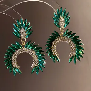 Close-up of elegant green crystal and rhinestone drop earrings in gold setting