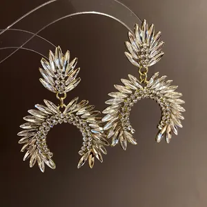 Close-up of sparkling crystal encrusted horseshoe drop earrings with golden frame