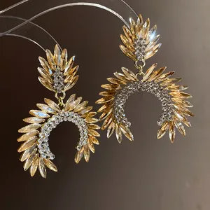 Detailed view of elegant gold-tone drop earrings with marquise champagne crystals.
