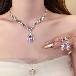 Close-up of elegant purple teardrop crystal necklace and matching earring set on a model