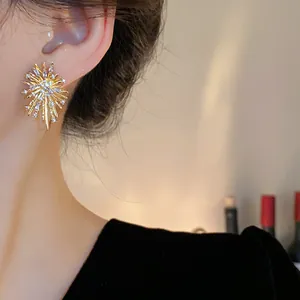 Close-up detail of elegant gold irregular firework earrings with sparkling zircon accents