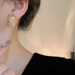 Close-up detail of a stunning gold firework earring featuring clear zircon stones