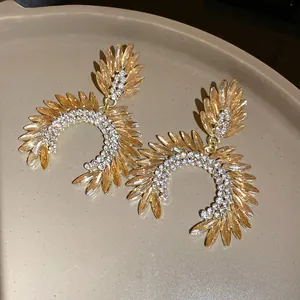 Detailed macro view of luxury marquise cut rhinestone earrings in warm golden tones.