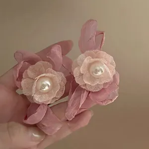 Detailed view of elegant handmade pink fabric flower earrings with a center white pearl