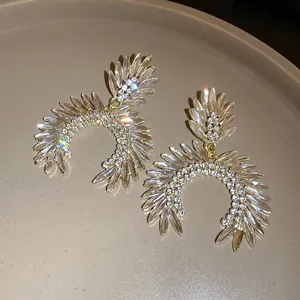 Close-up of sparkling marquise rhinestone drop earrings with silver needle posts.
