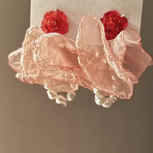 Exquisite close-up of handmade pink organza flower earrings with elegant pearls and red roses
