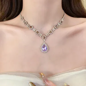 Detailed macro view of a sparkling purple teardrop pendant necklace with luxury rhinestones