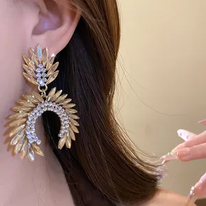 Close-up of luxury gold-toned drop earrings with marquise crystals and rhinestones