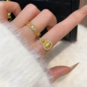 Close-up view of gold-plated rings featuring a sparkling gourd and floral design on a hand