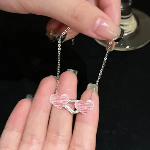 Detailed macro view of a delicate silver bracelet with double pink heart charms