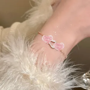 Close-up of elegant double pink heart bracelet with fine rose gold chain detail