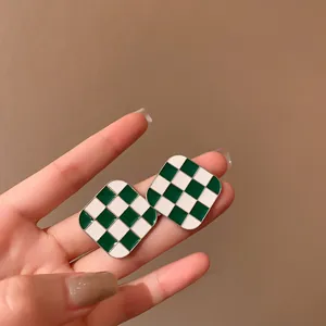 Detailed shot of retro green and white checkerboard square pattern stud earrings
