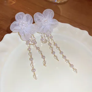 Élégantes boucles d'oreilles en argent avec fleurs en maille et pompons en perles.