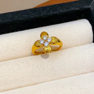 Close-up of a gold-plated flower ring with sparkling zircon center in a jewelry box.