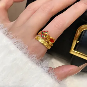 Close-up detail of a gold-plated ring with vibrant red and green enamel flower patterns