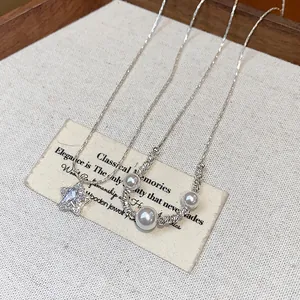 Close-up detail of a zircon star pendant and pearl necklace displayed on vintage card