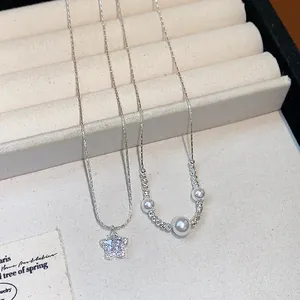 Detailed view of elegant zircon star pendant and pearl necklace on a velvet display tray