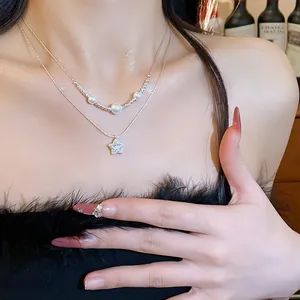 Close-up of elegant double-layered necklace with pearls and zircon star pendant