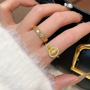 Close-up view of gold-plated rings featuring gourd and floral patterns with zircon stones.