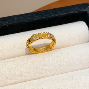 Close-up of gold-plated ring with zircon-encrusted flower motifs and beaded edges.