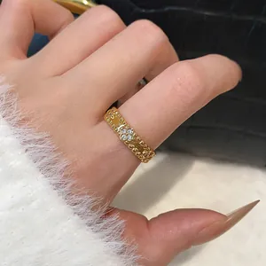 Detailed macro view of a gold plated flower ring with zircons worn on the index finger