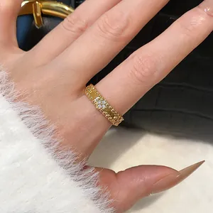 Close-up detail of a gold-plated flower ring with sparkling zircon inlays on a model's hand